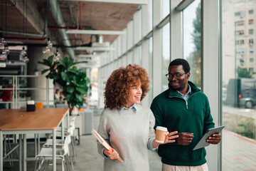 Diverse colleagues walking office corridor discussing business