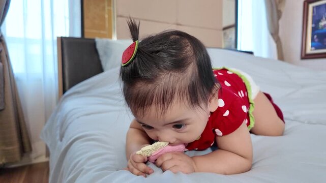 A 6-month-old baby girl chewing on a teething toy to soothe her sore gums