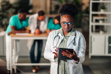 Black doctor using tablet for medical data
