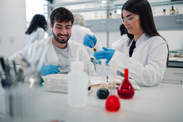 Young students conducting chemistry experiment in laboratory