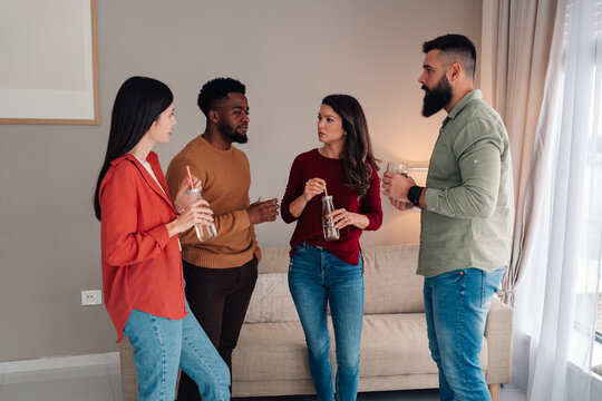Diverse friends talking and socializing at home gathering
