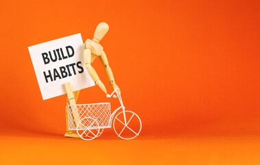 Fototapeta premium Build habits symbol. Concept word Build habits on beautiful white paper. Beautiful wooden clothespin. Businessman's model. Beautiful orange background. Business build habits concept. Copy space.