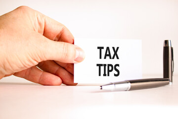 Tax tips symbol. Concept word Tax tips on beautiful white card. Beautiful black pen. Beautiful...