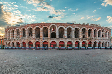 Ancient Roman amphitheater Arena di Verona at sunrise with dramatic sky and empty cobblestone Piazza Bra square, Verona old town, Veneto, Italy. Italian travel and touristic landmark. Ancient Rome