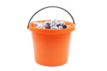 Orange halloween bucket filled with candy isolated on transparent background