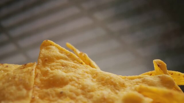 Corn chips, mexican nachos, slow motion footage of crispy yellow tortilla chips