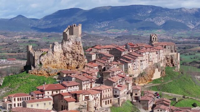 Aerial view of the dramatic Frias Castle perched atop a rocky crag, surrounded by the terracotta rooftops of the ancient town, Frias, Castilla y Leon, Spain.
