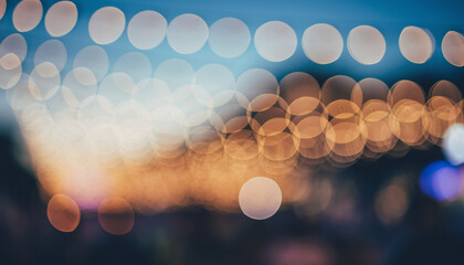 Abstract dark background with colorful glowing bokeh circles, bright night city lights, and holiday celebration blur pattern