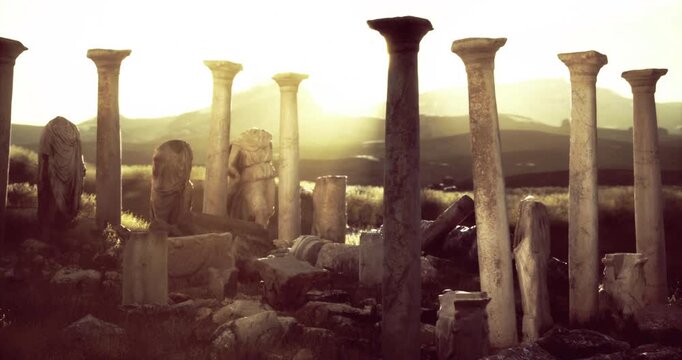 Weathered stone columns and sculptures reveal a rich history, bathed in golden light as the sun sets over the rolling hills, creating a serene atmosphere steeped in mystery.