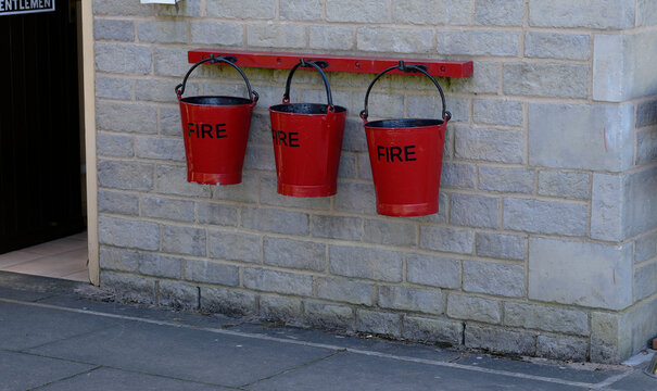 Vintage Red Fire Buckets hanging on a wall at a train station
