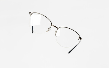 Stylish women’s eyeglasses with thin metal semi-rim frame on white background. Optical fashion...