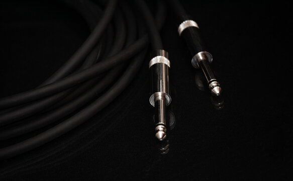 Two silver TRS connectors for the analog audio signal are placed against a black background. Professional jack connectors for sound equipment. Audiophile technologies concept.