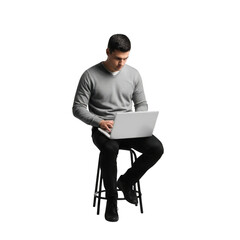 A man in a gray sweater and dark pants sits on a stool looking down at a laptop computer isolated on transparent background