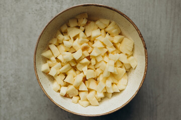 Top view of diced apples in bowl for cooking preparation.