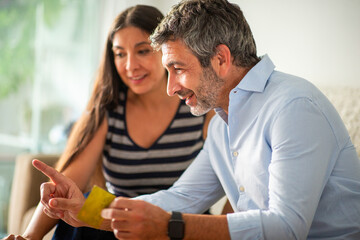 Smiling couple using credit card for online shopping at home