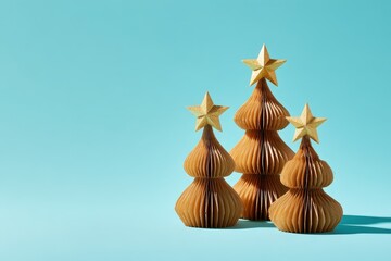 Three accordion style paper holiday decorations display star toppers against a bright cyan background