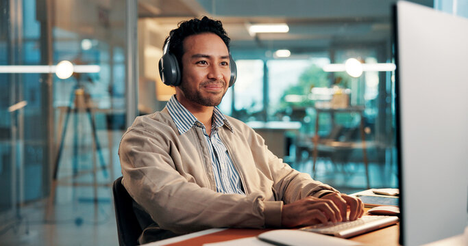 Headphones, typing and happy businessman with computer for music, copywriting or research. Audio, technology and content writer in workplace for streaming radio, editing article and info in office