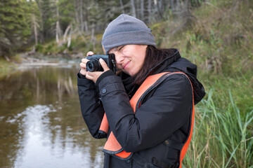 Peruvian Woman Takes Photographs of the Forest Landscape and the St. Lawrence River in Grand Makasti, Anticosti Island, Quebec, Canada