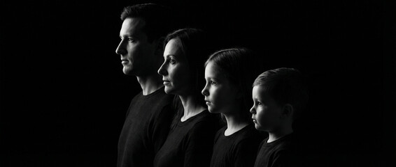 Family portrait in profile with four members against a dark background  