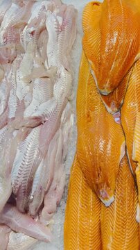 Fresh salmon and white fish fillets on ice in a close-up display