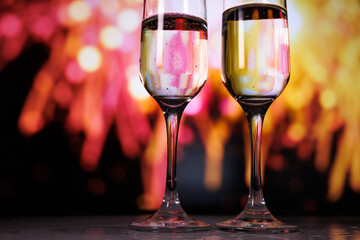 Two glasses of champagne against a backdrop of fireworks