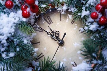 Closeup of holiday clock adorned with holly berries and sparkling decorations for celebrations.