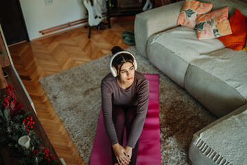 Obraz premium Woman exercising at home preparing for workout on yoga mat