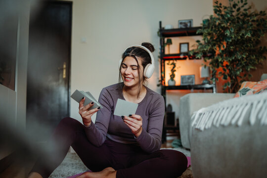 Woman studying with flashcards and headphones at home