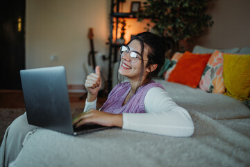 Young woman succeeding with remote work giving thumbs up