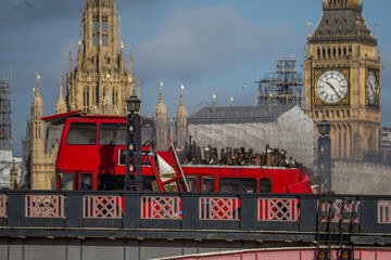 LONDON, UK -  7 2016.  A dramatic scene unfolds as a red double-decker bus explodes on Lambeth Bridge, with the iconic Parliament buildings in the background. 