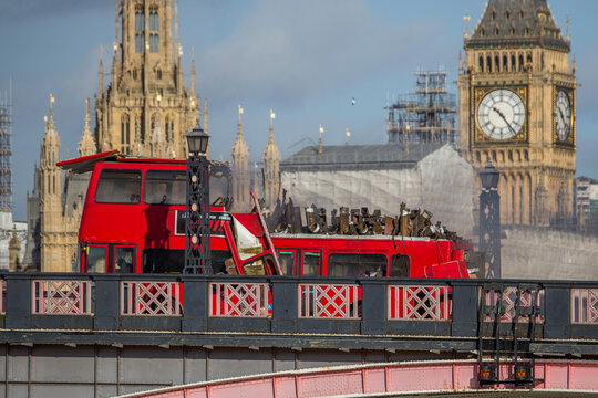 LONDON, UK -  7 2016.  A dramatic scene unfolds as a red double-decker bus explodes on Lambeth Bridge, with the iconic Parliament buildings in the background. 