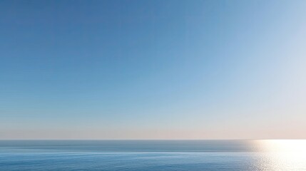 Obraz premium Tranquil Seascape with Clear Blue Sky and Gentle Ocean Waves Under the Warm Sunlight at Dusk