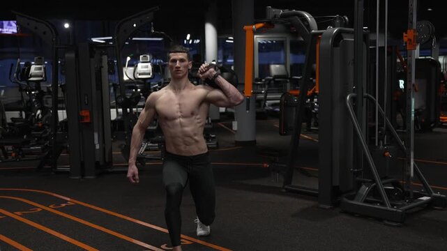Sportsman do lunge with kettlebell. Trainer do kettlebell lunge for strength at gym. Strength and fitness training. Gym workout exercise, motivation. Sport determination