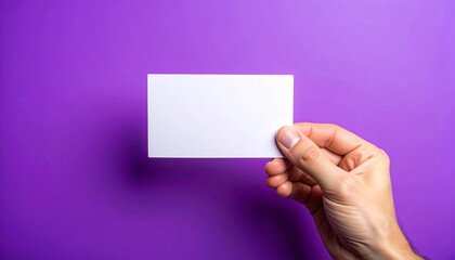 Obraz premium Hand holding blank card, vibrant purple background, minimalistic and clean presentation. Mock-up.