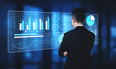 A businessman stands confidently in a modern office, analyzing data on a transparent screen filled with graphs and charts, representing business insights and trends. Gantry