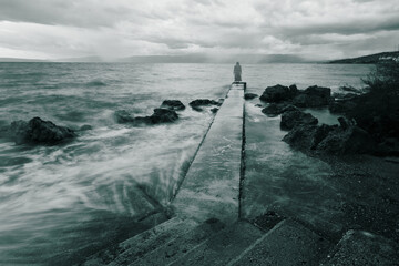 Horror scene of a specter stands on stormy sea pier
