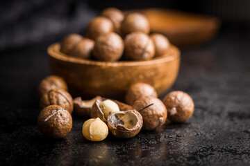 Tasty macadamia nuts on black table.