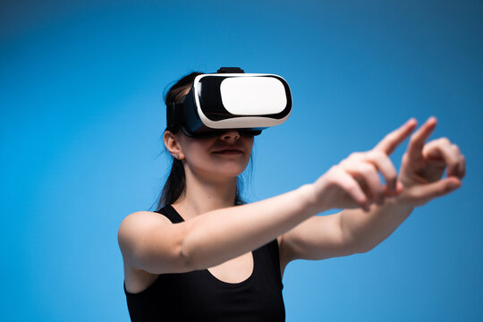 Woman wearing VR headset exploring digital space with expressive hand gestures in virtual environment