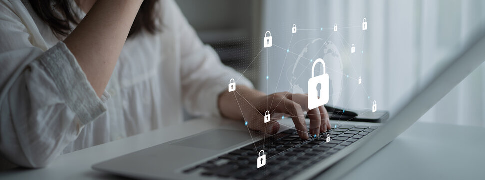 A woman interacts with a laptop while surrounded by virtual cybersecurity icons, emphasizing the importance of online security, privacy, and data protection in modern digital life. Gantry