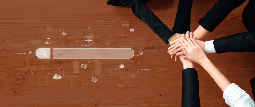 A diverse group of business individuals joins hands in a display of teamwork and collaboration, with a digital search bar motif enhancing their innovative workspace setting. Trope