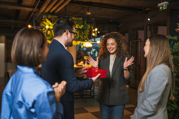 Colleagues celebrating holiday season with surprise gift giving