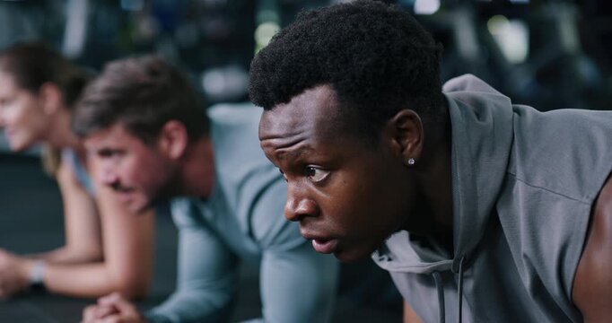 Exercise, men and plank with group for training, talk and breathing for wellness on floor. People, core fitness and friends in health club for balance, intense challenge and strength workout in gym