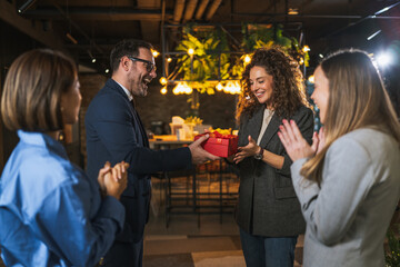 Colleagues celebrating holiday season with surprise gift giving