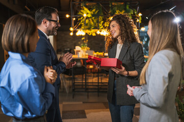 Colleagues celebrating holiday season with surprise gift giving