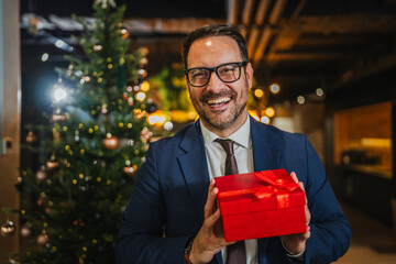 Happy businessman receiving christmas gift at office party