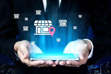 A businessman showcases a tablet displaying storefront icons and a location pin on a digital map, representing modern retail and e-commerce innovation in a vibrant urban setting. Gantry