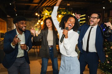 Diverse business people celebrating office party karaoke