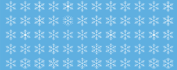 Delicate snowflakes falling gently on a serene blue background, perfect for winter holiday designs and festive seasonal promotions