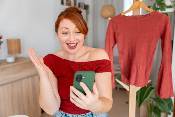 Woman running online second-hand clothing business, live streaming with phone for sustainable...