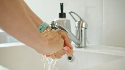 Woman Washing Hands Over Sink